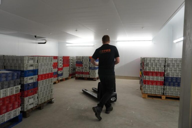 A worker taking meat into the freezer